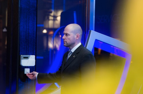 Un agent de sécurité se tenant près d’un poste de contrôle à l’entrée.